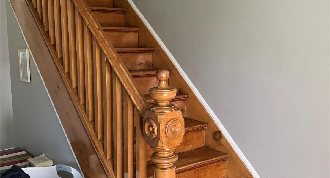 an oak wood staircase that leads from the main floor to the second floor